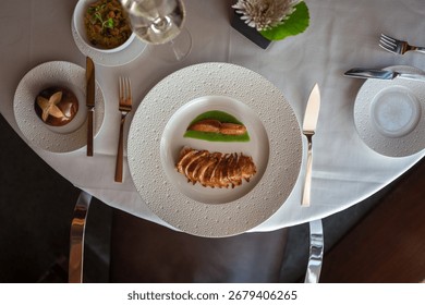 An overhead shot of an elegant table setting with a plated lobster dish and wine glass at a fine dining restaurant.