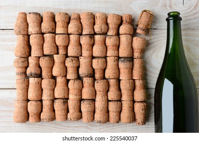 Overhead Shot Of A Empty Champagne Bottle Without Label And Corks. Closeup On A Rustic White Wood Table. Horizontal Format With Copy Space.