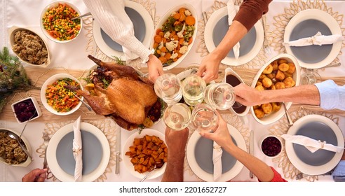 Overhead Shot Of Family Celebrating Christmas At Home Making Toast With Wine Glasses