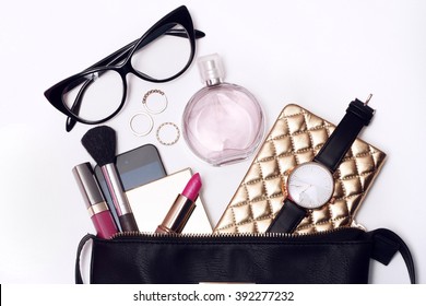 Overhead shot. Fashion accessories : black watch, rim glasses and perfume in black feminine beautician