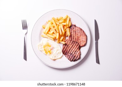 Overhead Shot Of French Fries With Grilled Pork And Tuna Salad Isolated On White Background.