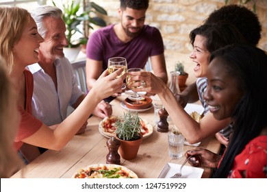 Overhead Shot Of Friends Sharing Tapas At A Wooden Table