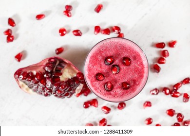 Overhead Shot - Glass With Pomegranate Smoothie, Fruit Berries Scattered Over White Desk Around