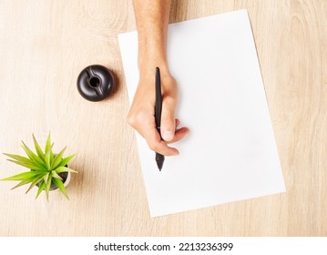 Overhead Shot Hand Writing With A Pen Over Empty White Sheet Of Paper On A Desk Woody Background Decorated With Small Plants