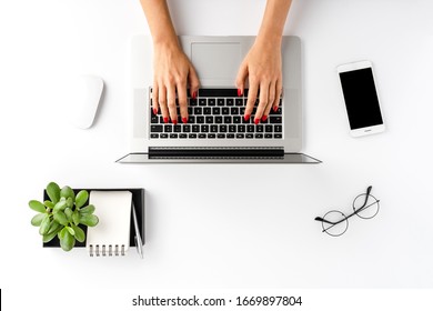 Overhead Shot Of Woman’s Hands Working On Laptop On White Table With Accessories. Office Desktop. Flat Lay