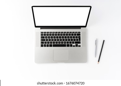 Overhead shot of laptop with empty screen and pens on white desktop. Business background. Flat lay