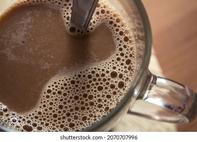 Overhead Shot Of A Latte Macchiato With Froth In A Glass Cup - Long Coffee Mug On The Left