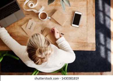 Overhead Shot Looking Down On Woman Writing In Generic Thank You Card