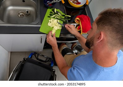 overhead shot of a man with disability cooking outside of the wheelchair - Shutterstock ID 2053174895