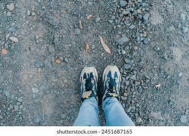 overhead shot of a man's feet in old sneakers on the stone path with space to add text - Powered by Shutterstock