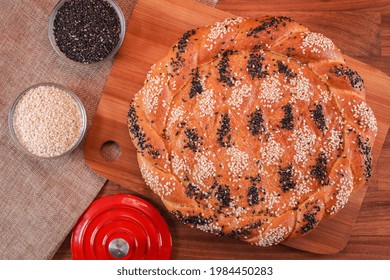 An Overhead Shot Of Naan Roghani Topped With Black And White Sesame Seeds On  A Wooden Bread