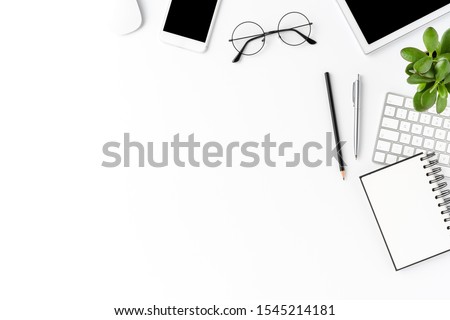 Overhead shot of office desktop with accessories on white table. Business background