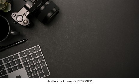 Overhead shot of an office workspace with keyboard, camera, coffee cup and copy space for your product display on black background. Modern black workspace concept
