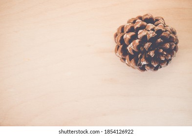 An Overhead Shot Of A Pinecone On A Wooden Surface With Space For Your Text