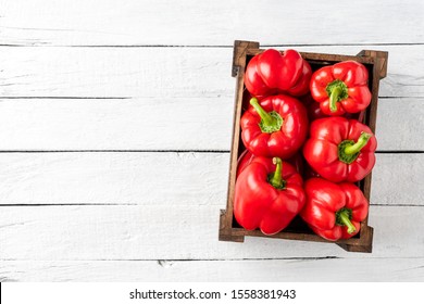 Overhead Shot Of Red Bell Pepper In Box On White Wooden Table With Copyspace. Sweet Paprika