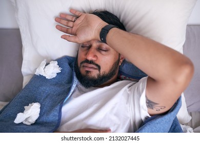 An Overhead Shot Of A Sick Man In Bed With His Hand To His Forehead. High Quality Photo