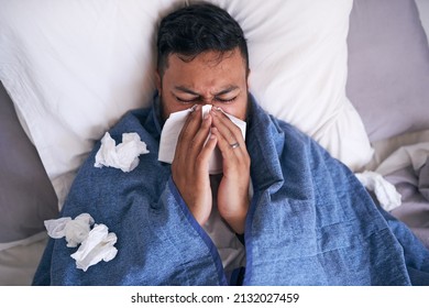 An Overhead Shot Of A Sick Man Blowing His Nose In Bed. High Quality Photo