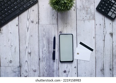 Overhead Shot Of Smart Phone , Credit Card And Pen On Table 