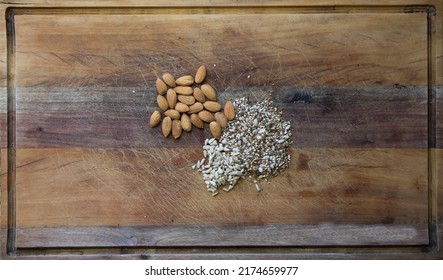 Overhead Shot Of Sunflower Seeds, Almonds And Chia Scattered On A Wooden Table