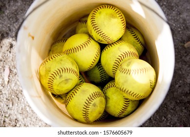 An overhead shot of tennis balls in a white bucket