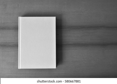 Overhead Shot Of A White Blank Book On Wooden Table. Black And White Photo