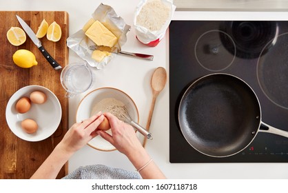 Overhead Shot Of Woman In Kitchen With Ingredients Making Pancakes Or Crepes For Pancake Day