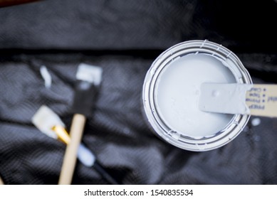 An Overhead Shot Of A Wooden Pain Mixer In The Paint Can With A Blurred Background