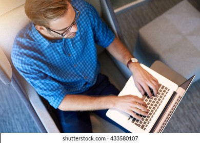 Overhead shot of a young designer typing on his laptop while working in a modern workspace - Powered by Shutterstock