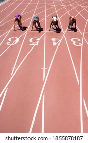 Overhead Shot Of Young Female Runners At Their Starting Blocks Waiting For The Race Start At An Athletics Competition At The Track