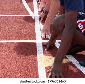 Overhead Sideview Of Hands And Arms Of High School Boys Ready To Start A Sprint Race While At Track Practice.