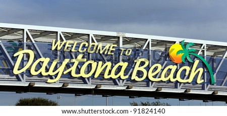 An overhead sign welcoming travelers to Daytona Beach, Florida.