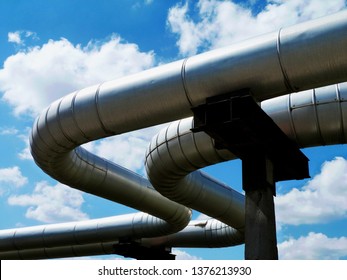 Overhead Steel Pipeline With Aluminum Shroud Covered Gas Or Heating Supply Tubes On Concrete Support. Blue Sky. Natural Gas Supply Shortage And Energy Supply Security Concept. Europe, Russia, Germany.