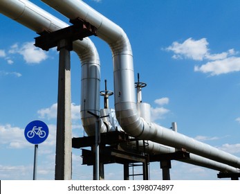 Overhead Steel Pipeline With Aluminum Shroud Covered Gas Or Heating Supply Tubes On Concrete Support. Blue Sky. Natural Gas Supply Shortage And Energy Supply Security Concept. Europe, Russia, Germany.