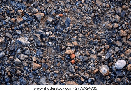 Overhead texture composition revealing a highly complex and chaotic arrangement of rough crushed gravel and dirt covering the ground entirely.