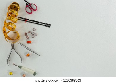 Overhead of thread rolls and various tools on white background