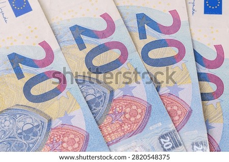 Overhead top down view of twenty and fifty euro banknotes scattered across the frame, background pattern representing business finance and prosperity