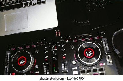 Overhead Top Shot Of Dj Controling Red Party Dj Audio Equipment.Turntable Top View High Quality Mixing Controller Disc Jockey In Night Club And Notebook .Pro Audio Equipment On Stage In Nightclub.