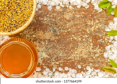 Overhead Top View Of Bowls With Bee Pollen And Honey On Wooden Table. Flower Petals Frame