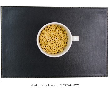 Overhead Top View Of Cereal Rings Falling In Bowl Froot Loops To Eat With Milk Cereal. Nourishing Healthy Natural Breakfast. Good Nutrition