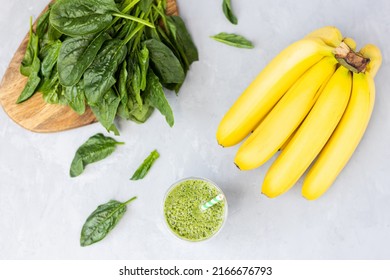 Overhead Top View Of Vegetarian Green Smoothie With Avocado, Spinach Leaves, Banana In Glass On Gray Concrete Background. Raw, Vegan, Vegetarian, Alkaline Food, Healthy Lifestyle Detox Concept