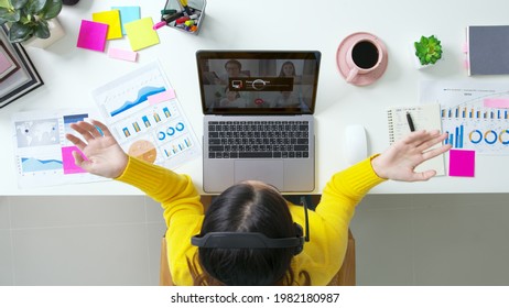 Overhead top view young asian woman employee work from home using computer notebook videocall meeting conference angry annoy with low poor unreliable internet wifi connection problem issue outage.