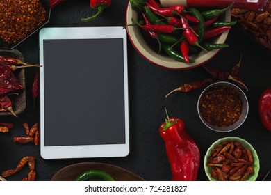 Overhead of various spices with digital tablet on black background - Powered by Shutterstock