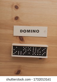 An Overhead Vertical Shot Of A Domino Sign And The Dominoes Collected And Placed In A Box