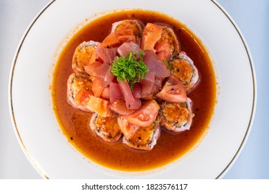 Overhead View Of Ahi Tuna Stacked Upon California Roll And Tomatoes Delicately Presented On A Plate To Eat.