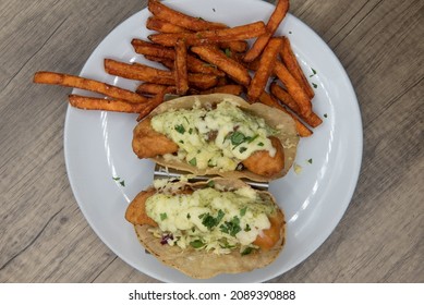 Overhead View Of Artistic Presentation Of Crispy Deep Fried Fish Tacos Covered In Melted Cheese And Served With Crunchy French Fries.