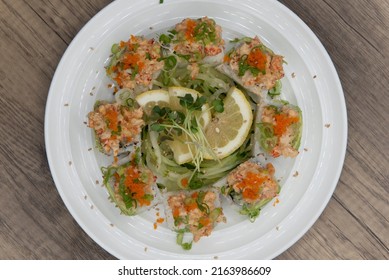 Overhead View Of Asian Cuisine Sushi Roll With Lobster And Shrimp Tempura Topped With Green Onion And Masago For A Very Hearty Meal.