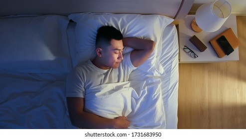 Overhead View Of Asian Man Sleep Well With Smile At Night 