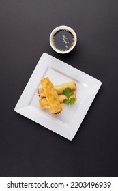 Overhead View Of Asian Spring Rolls On White Plate And Soy Sauce On Grey Background. Asian Tasty Home Cooked Food And Healthy Eating.