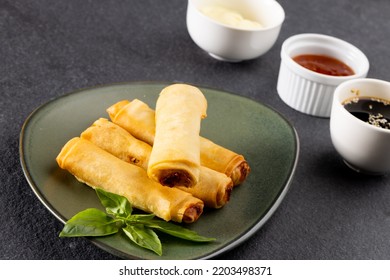 Overhead View Of Asian Spring Rolls On Grey Plate And Condiments On Grey Background. Asian Tasty Home Cooked Food And Healthy Eating.