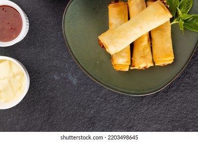 Overhead View Of Asian Spring Rolls On Grey Plate And Condiments On Grey Background. Asian Tasty Home Cooked Food And Healthy Eating.